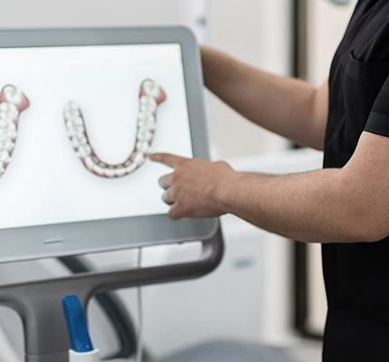 a dentist pointing to a chairside monitor