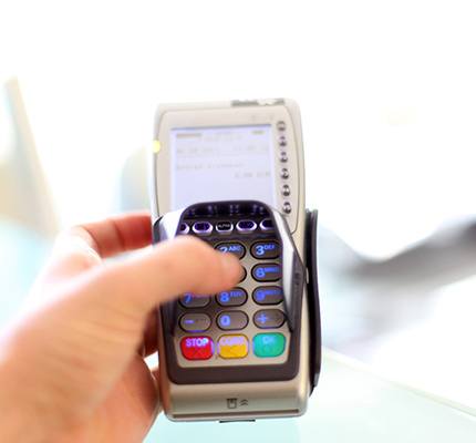 a person typing their PIN into a credit card machine