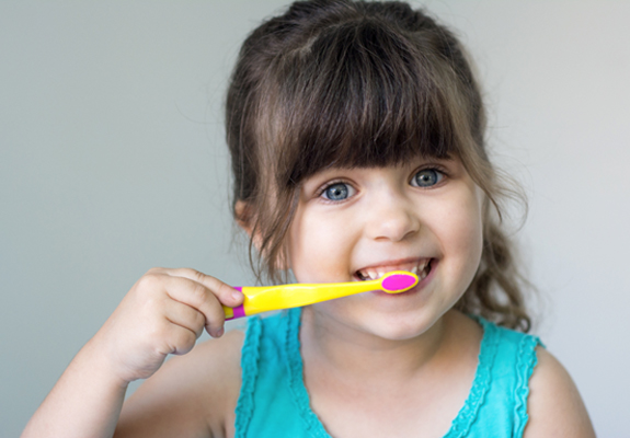 A little girl brushing her teeth after seeing a children’s dentist in Fanwood