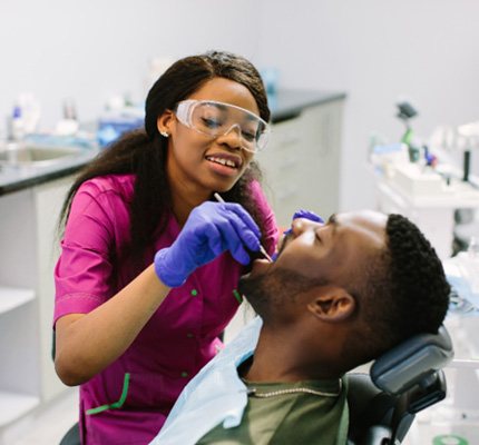 Cosmetic dentist examining patient's teeth 