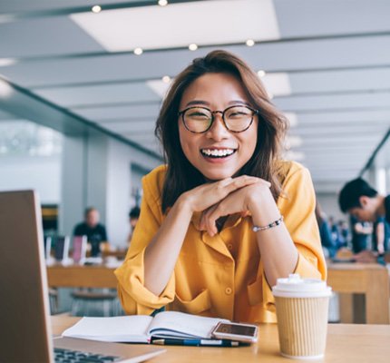 Woman in yellow shirt smiling in office 