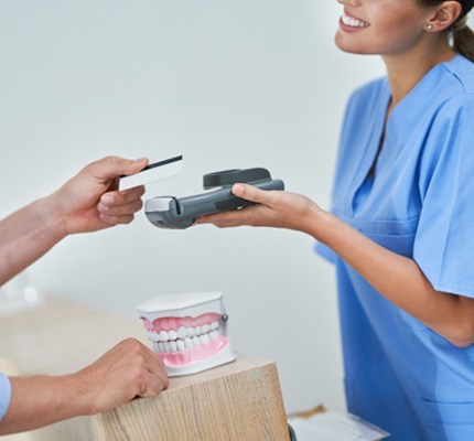 Patient paying for the cost of cosmetic dentistry in Fanwood 