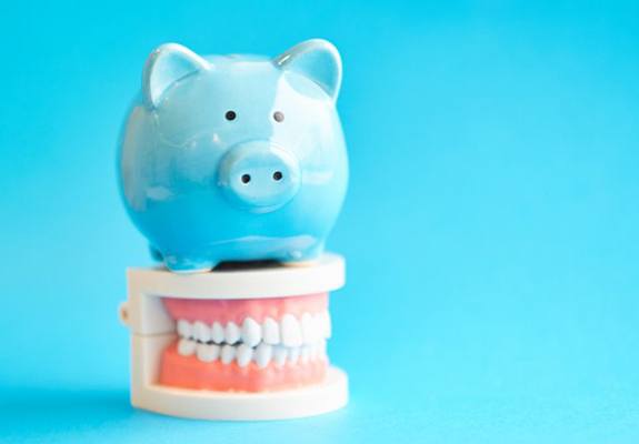 blue piggy bank sitting on top of a set of dentures in Fanwood 