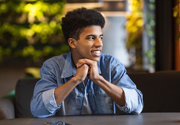 person looking out a window smiling