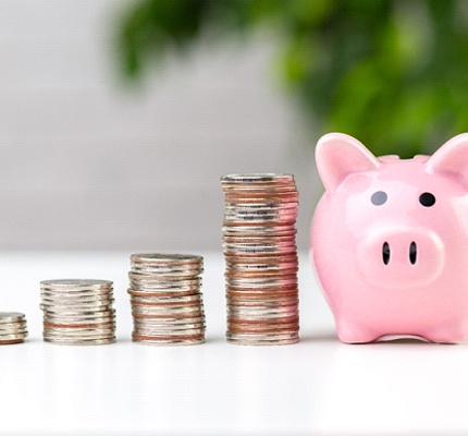 Piggy bank and coins represent saving money on emergency dental care