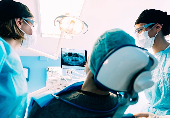 a dentist showing a patient their X-rays