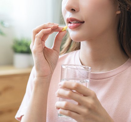 a woman taking a pill