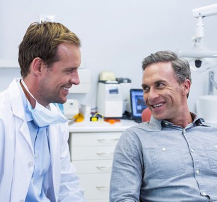 A dentist and patient speaking with each other