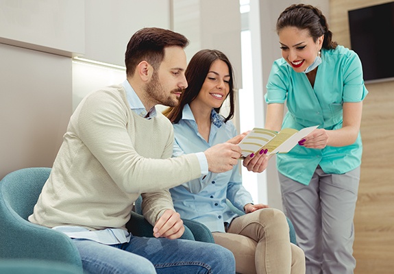 Man and woman checking in at dental reception desk