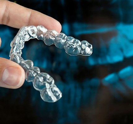 hand holding an Invisalign clear aligner 