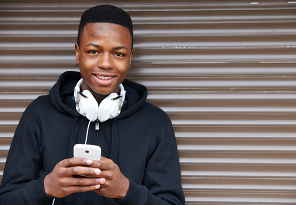 teenager smiling and using their cellphone