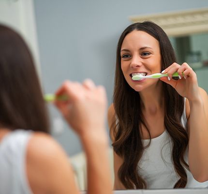 Woman brushing teeth in Fanwood