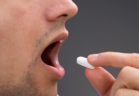 Man taking an oral sedative pill