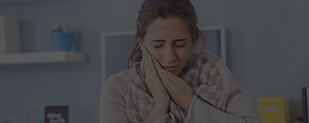 Woman holding cheek in pain