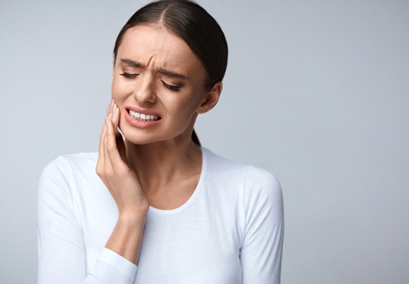 Woman in white shirt with tooth pain