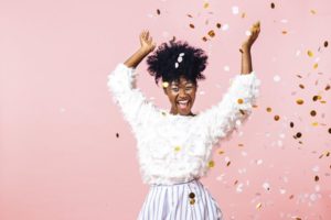 Woman celebrating New Year's resolutions by throwing confetti 