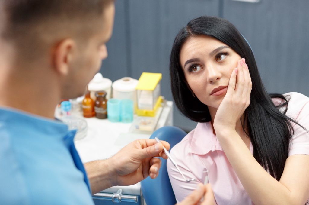 Woman visiting the dentist for a dental emergency.