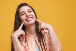 A patient pointing towards her smile