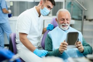 a man smiling and talking with his dentist