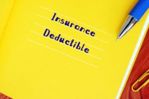 “Insurance deductible” written on yellow notebook paper